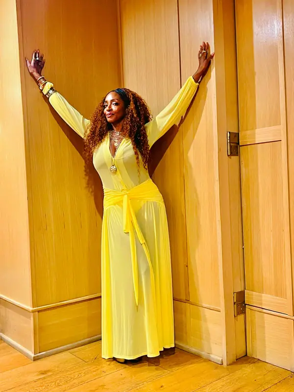 Kandace Lindsey in a yellow dress with arms outstretched